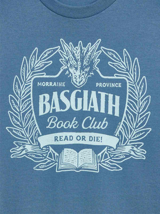 A close-up of a heathered blue t-shirt featuring a white graphic print of a dragon, laurel wreath, and an open book with the text 'BASGIATH Book Club' and 'READ OR DIE!'.