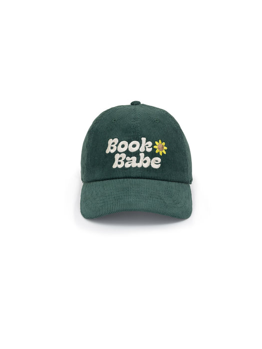 A dark green corduroy baseball cap with 'Book Babe' written on it and a small floral design next to the text.