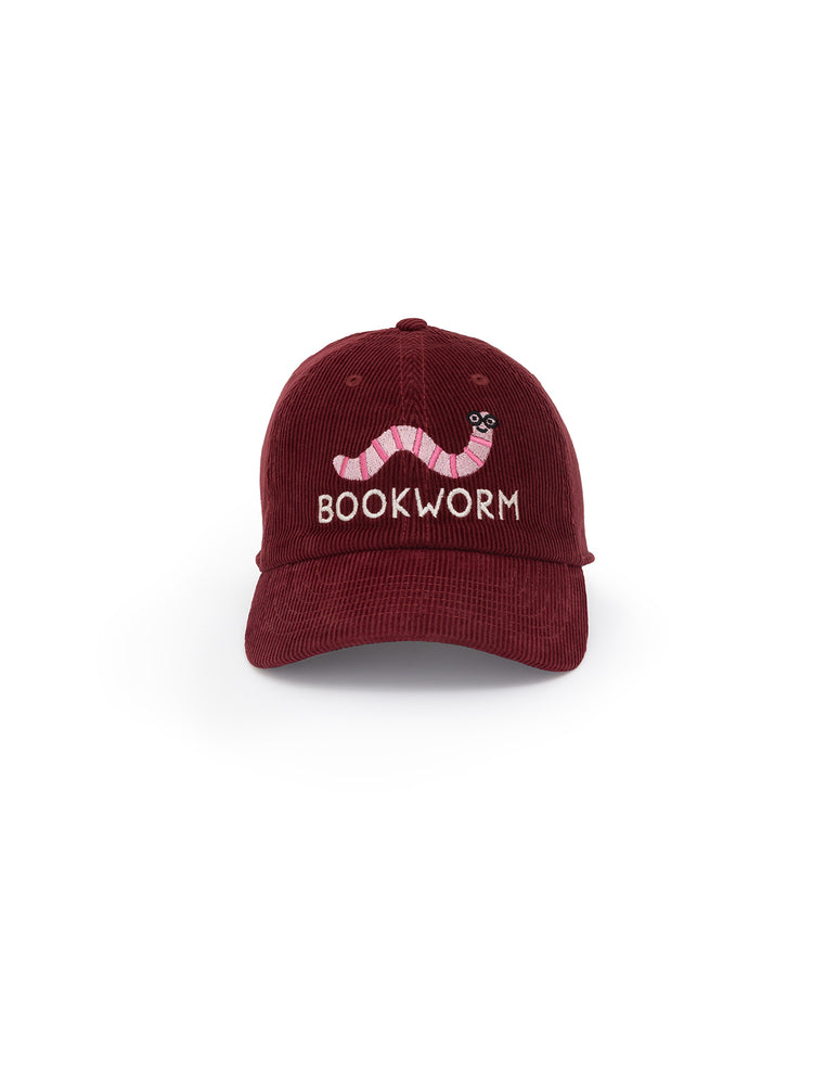 A burgundy corduroy baseball cap with 'BOOKWORM' text and a worm illustration in pink on the front.
