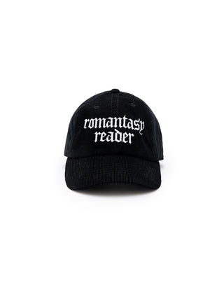 A black corduroy baseball cap with 'romantasy reader' embroidered in white text on the front.