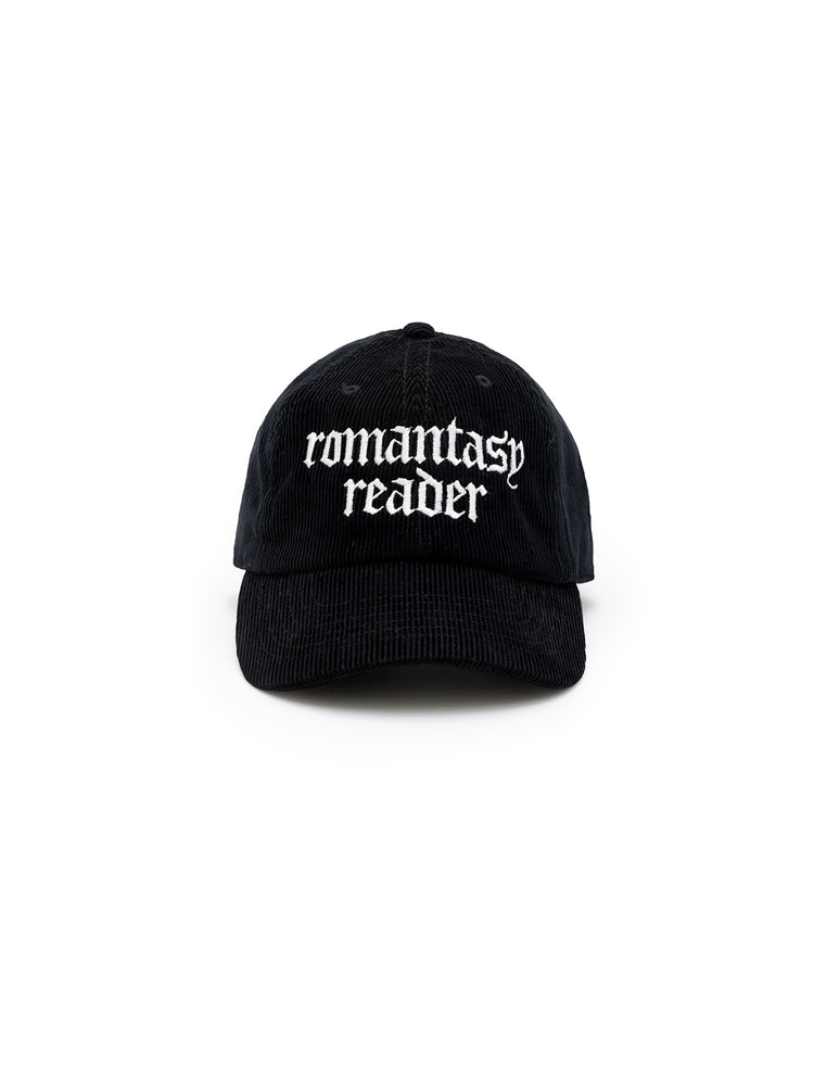 A black corduroy baseball cap with 'romantasy reader' embroidered in white text on the front.