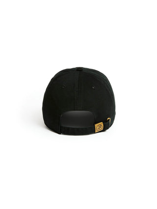 A black baseball cap shown from the back, featuring a black adjustable strap with a small gold-tone metal logo badge on the side, set against a plain white background.