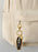 Keychain with skeleton design attached to a beige corduroy bag.