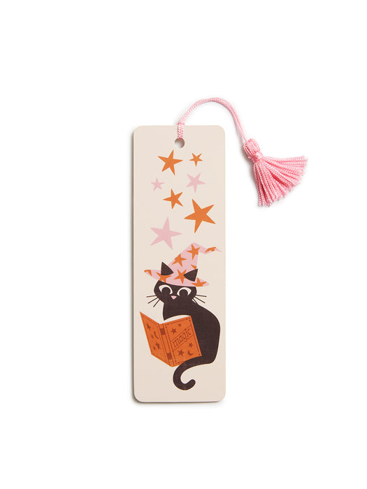 A rectangular beige paper bookmark with a pink tassel, featuring an illustration of a black cat reading an orange book under pink and orange stars.