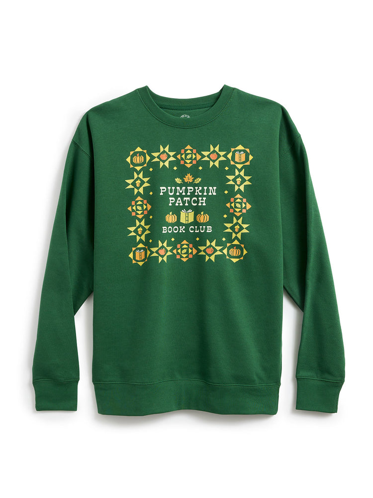 A green crewneck sweatshirt featuring a 'Pumpkin Patch Book Club' graphic on the chest, surrounded by a decorative border of pumpkins and geometric patterns in yellow, orange, and white.