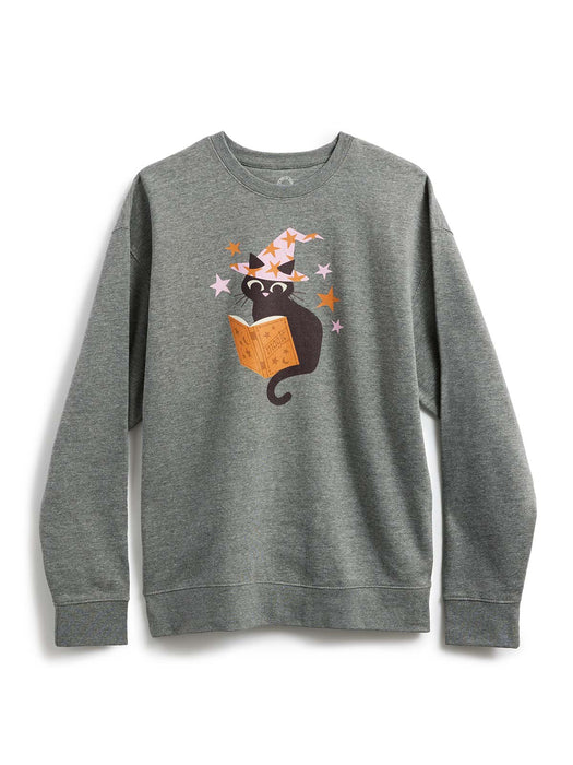 A heather gray crewneck sweatshirt featuring a graphic of a black cat wearing a witch hat and reading an orange book, surrounded by small stars.