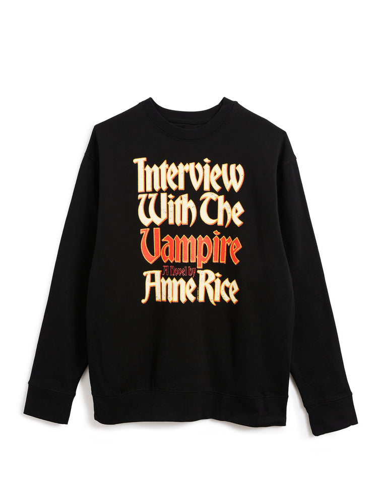 A black crewneck sweatshirt featuring a stylized graphic text print on the front that reads 'Interview With The Vampire' in a gothic font, with 'A Novel By Anne Rice' in orange-red lettering.