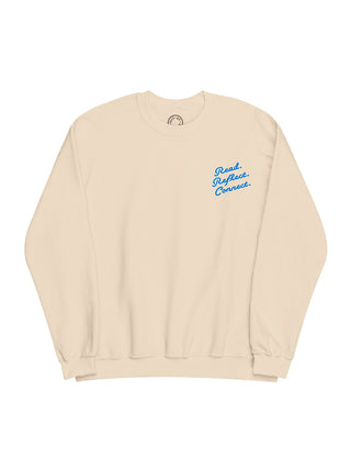 A cream-colored crewneck sweatshirt with blue cursive text on the left chest reading 'Read. Reflect. Connect.'