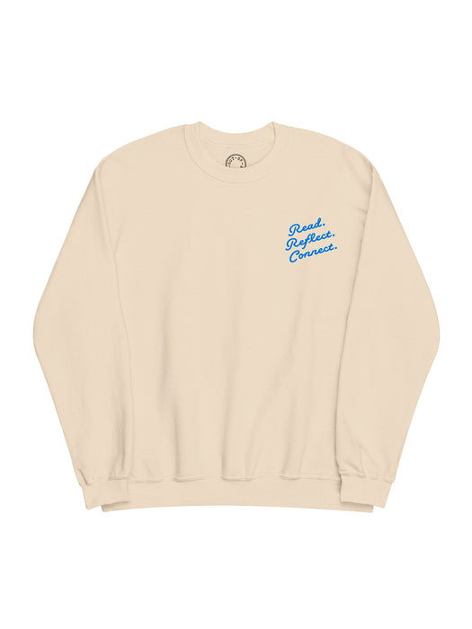 A cream-colored crewneck sweatshirt with blue cursive text on the left chest reading 'Read. Reflect. Connect.'