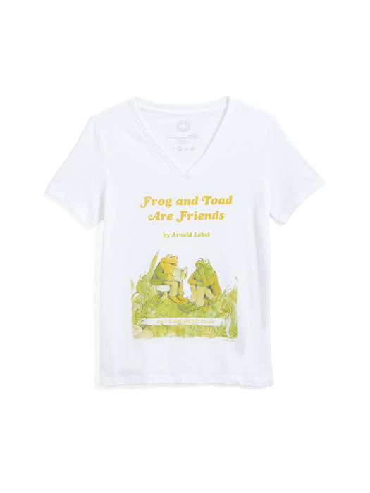 A white short-sleeve V-neck t-shirt featuring a graphic print of the classic 'Frog and Toad Are Friends' book cover, including the title in yellow text and an illustration of the characters on a green grassy field.