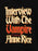 A close-up of a black v-neck t-shirt featuring a large, stylized graphic print of the book cover for 'Interview With The Vampire A Novel by Anne Rice' in a distressed gothic font.