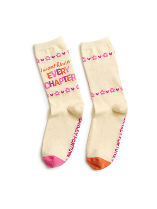 Beige socks with colorful text and patterns on a white background