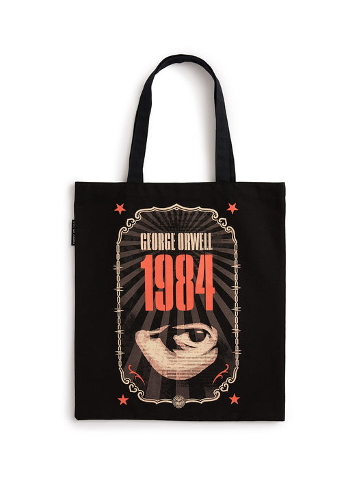 A black canvas tote bag featuring a graphic print of the book cover for George Orwell's 1984. The design includes the title '1984' in bold red-orange text, an eye illustration, and decorative borders, with 'GEORGE ORWELL' printed above.