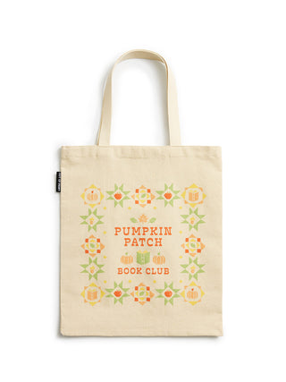 A cream-colored canvas tote bag with two shoulder straps, featuring a 'Pumpkin Patch Book Club' design with orange text and a border of orange and green quilted pattern motifs, shown against a plain white background.