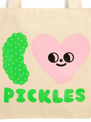 A beige canvas tote bag featuring a graphic design with a green pickle, a pink heart with a face, and the word 'PICKLES' in green letters.