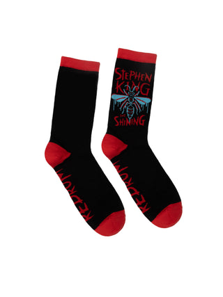 A pair of black socks with red trim, featuring the text 'Stephen King' and the title 'Shining' from the novel by Stephen King.