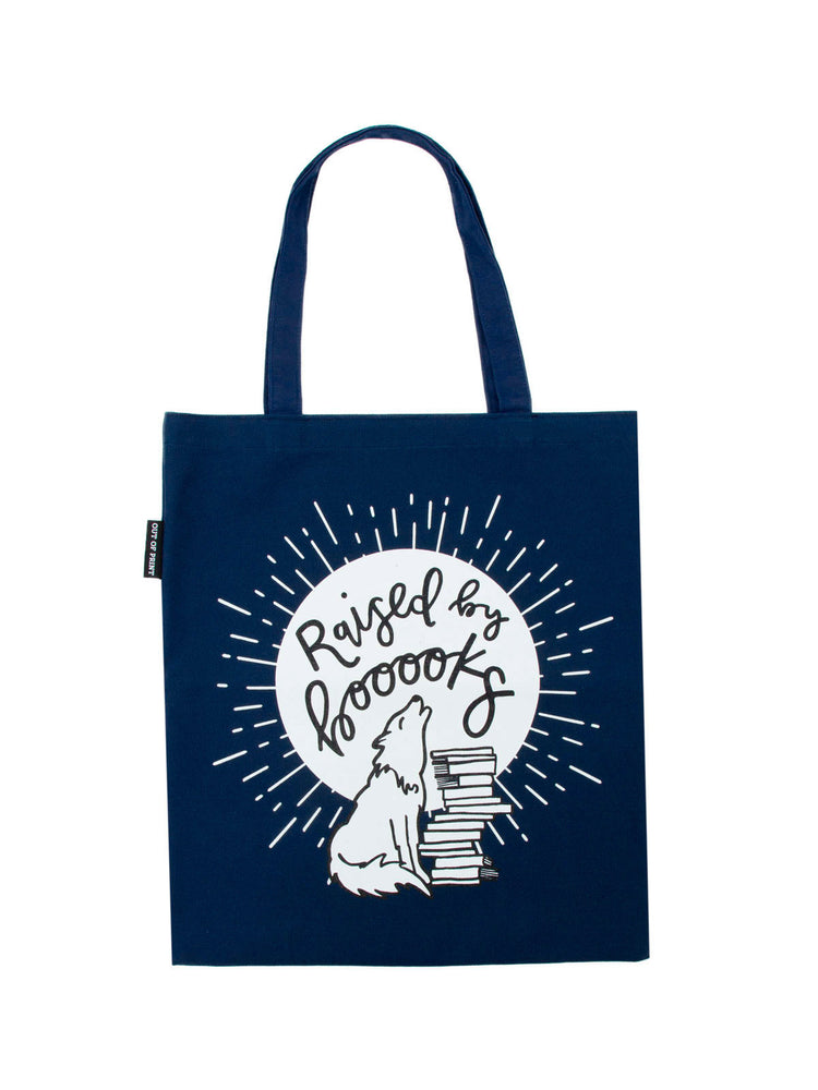 A navy-colored cotton canvas tote bag with the phrase 'Raised by books' printed in white, accompanied by an illustration of a bookshelf.